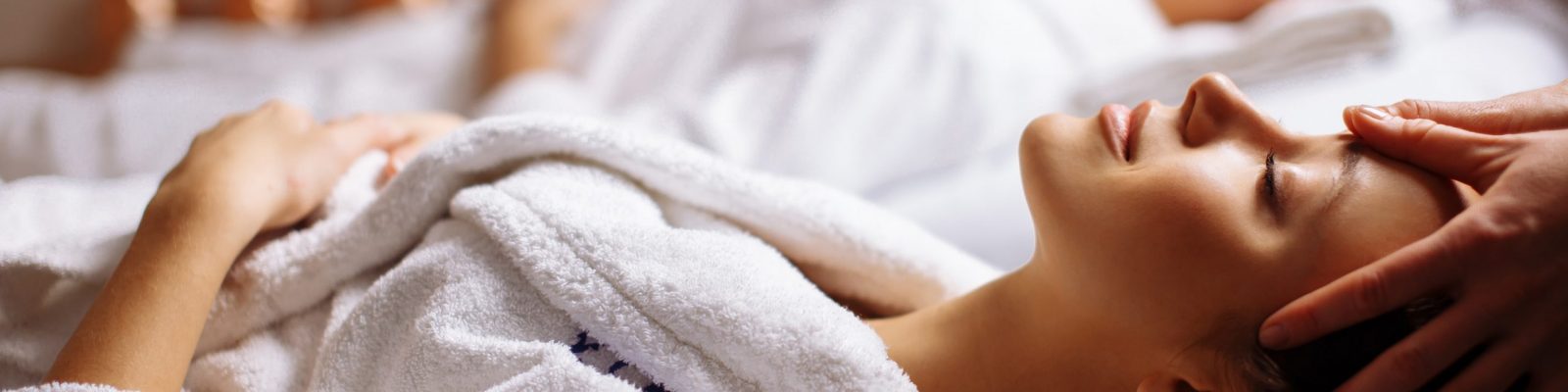 Young couple receiving head massage at beauty spa